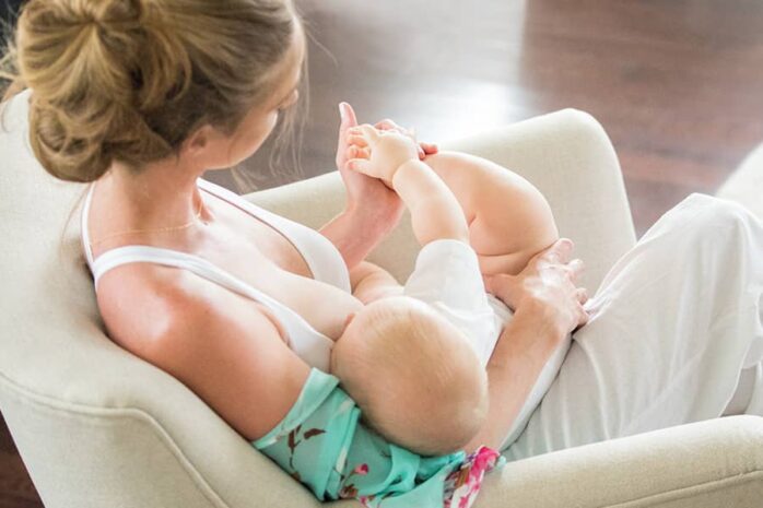 Vrouw in borstvoedingslingerie geeft borstvoeding aan baby