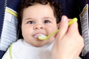 Jonge baby eet volgens het voedingsschema van baby 5 maanden