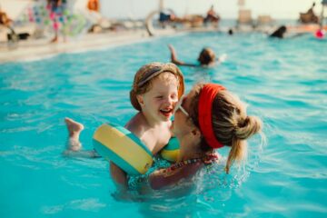 Moeder speelt met peuter in een zwembad