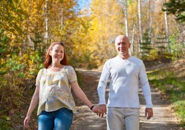 Aanstaande ouders wandelen in het bos en denken na over de veranderingen in zorgverzekering 2025