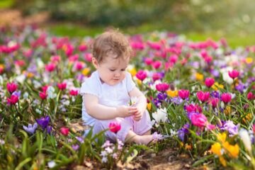 Baby met een van de mooiste lente namen in een veld met bloemen.