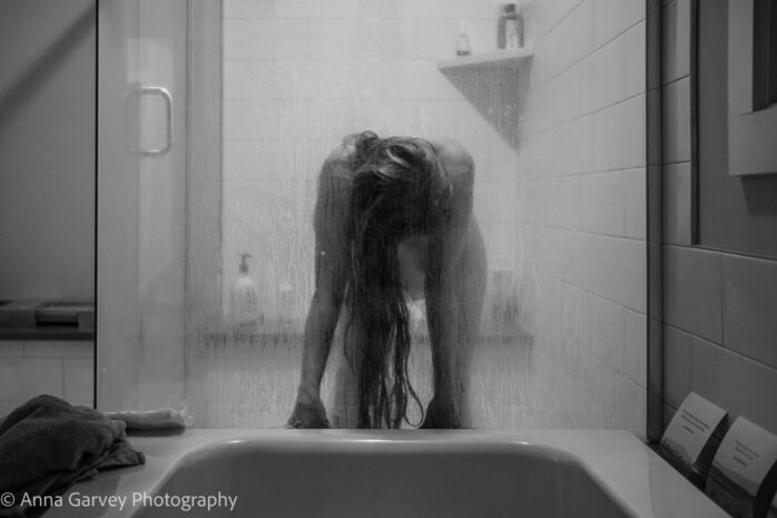 Vrouw die aan het bevallen is in de badkamer