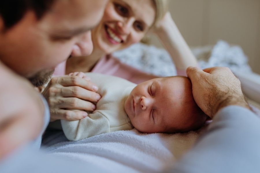 Ouders liggen liefdevol bij pasgeboren baby en beschermen hem met een prik tegen het RS-virus