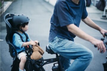 Kindje zit achterop de fiets in een fietsstoeltje