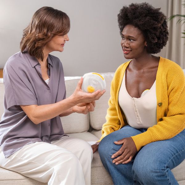 Een vrouw met een baby van 4 weken oud en een borstpomp van Medela