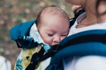 Baby zit bij zijn moeder in de Beste draagzak
