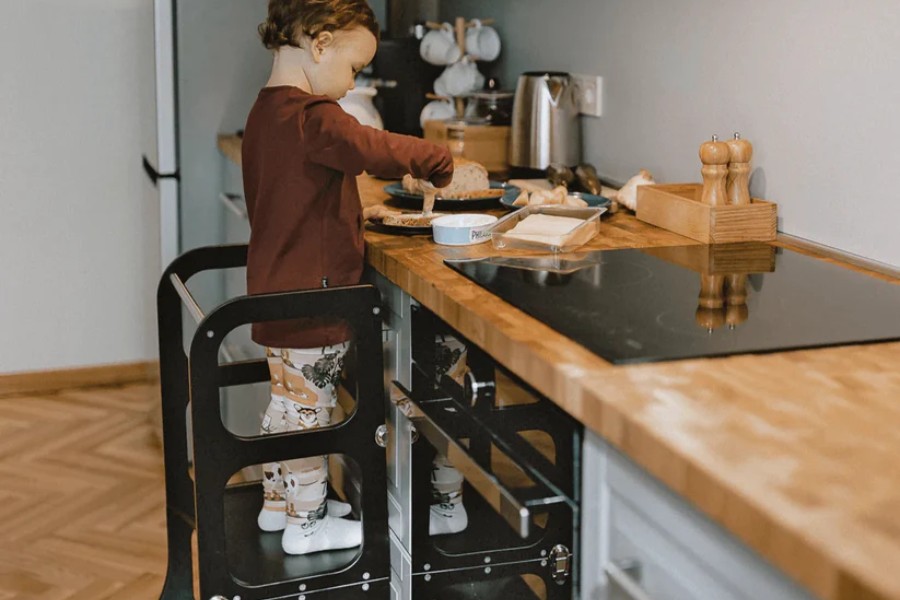 Kindje helpt mee in de keuken met een leertoren