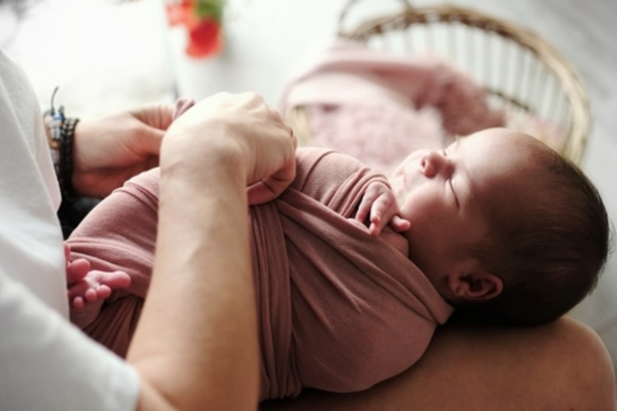 Baby wordt ingebakerd in beste inbakerzak