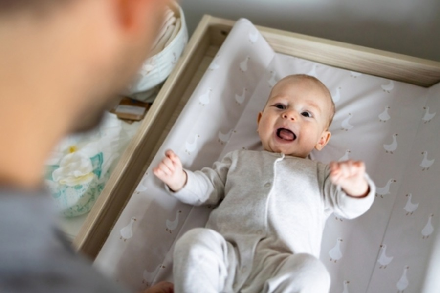lachende baby wordt verschoond op beste commode