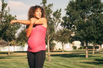 Zwangere vrouw is buiten aan het sporten, ze doet een powermama workout