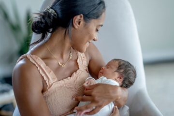 Moeder met baby is in de fase van matrescentie met haar kindje aan het knuffelen