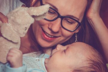Moeder knuffelt met haar baby die een van de populaire jongensnamen van 2027 draagt