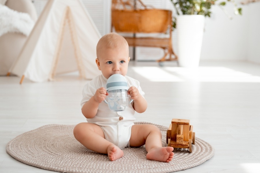 Baby drinkt uit drinkbeker