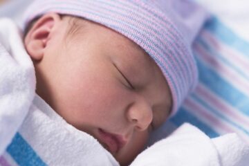 pasgeboren slaapt met babymutsje op