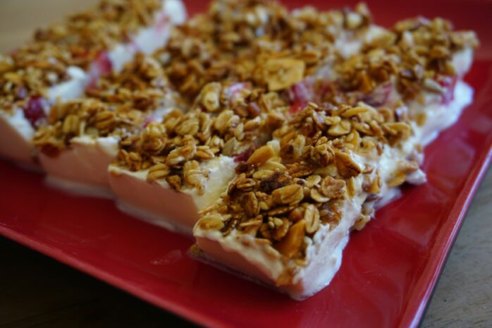 Gezonde snacks: frozen yoghurt bar met granola en aardbeien