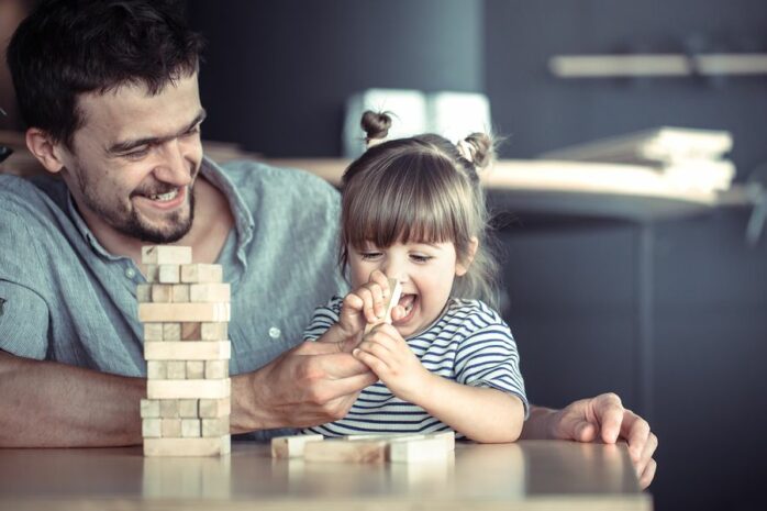 Papa en peuter spelen samen spelletje als beloning