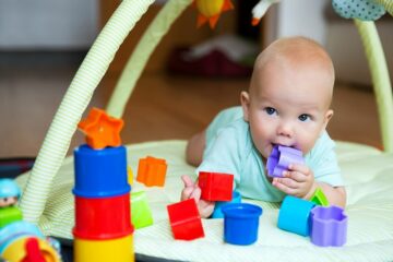Baby ontdekt blokje door het in zijn mond te stoppen