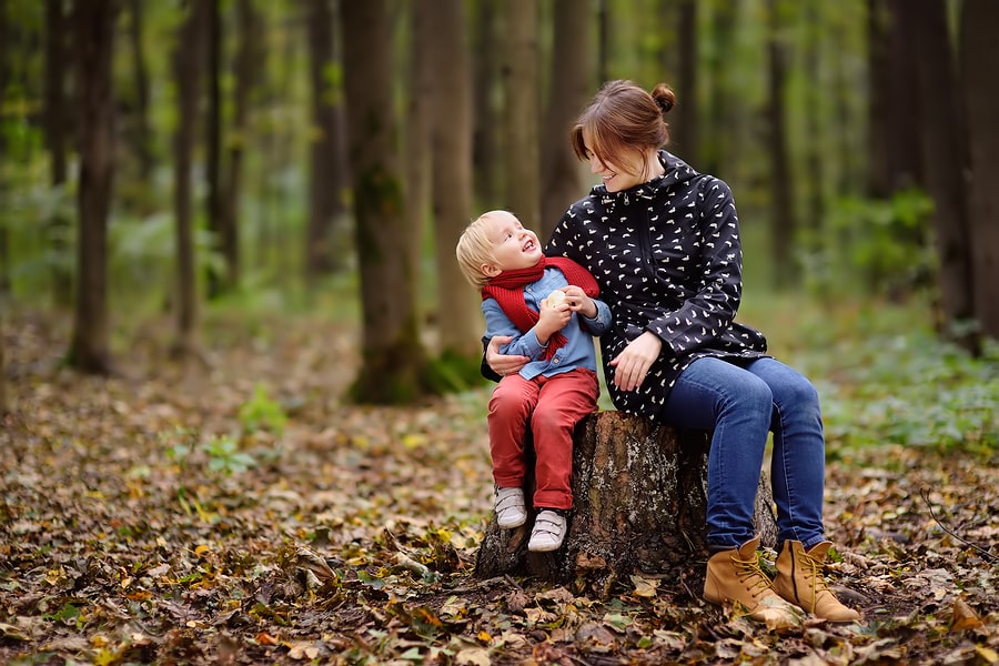 Moeder en peuter zijn aan het buitenspelen in de herfst