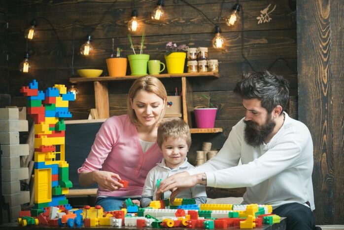 Peuter speelt met ouders met constructiespeelgoed