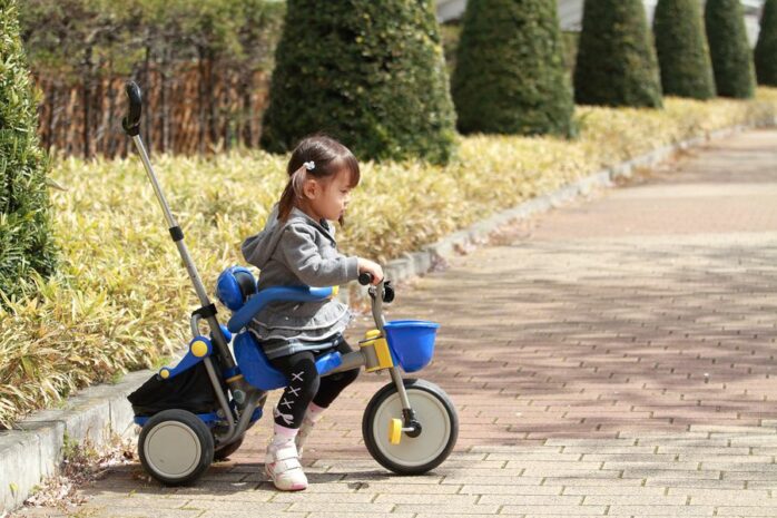 Peuter van 2 jaar met speelgoed driewieler