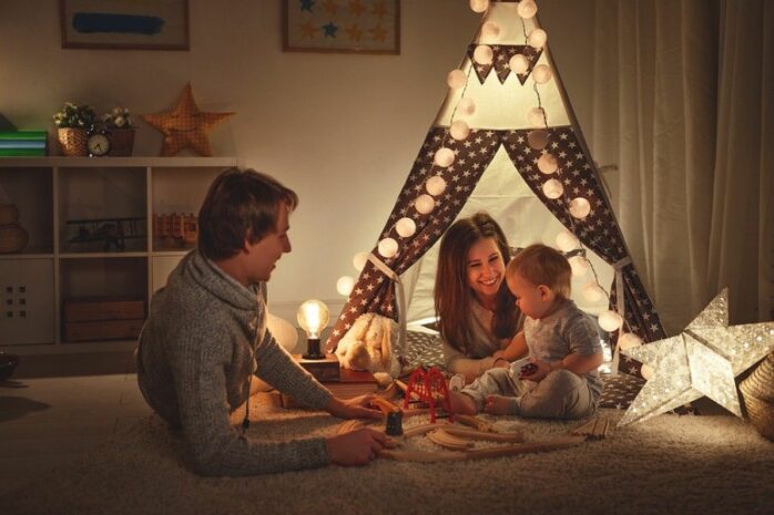 peuter speelt met ouders in kinderkamer met gezellige verlichting