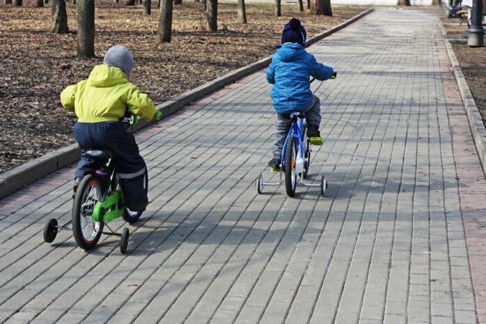 Peuters oefenen op hun kinderfiets met zijwieltjes