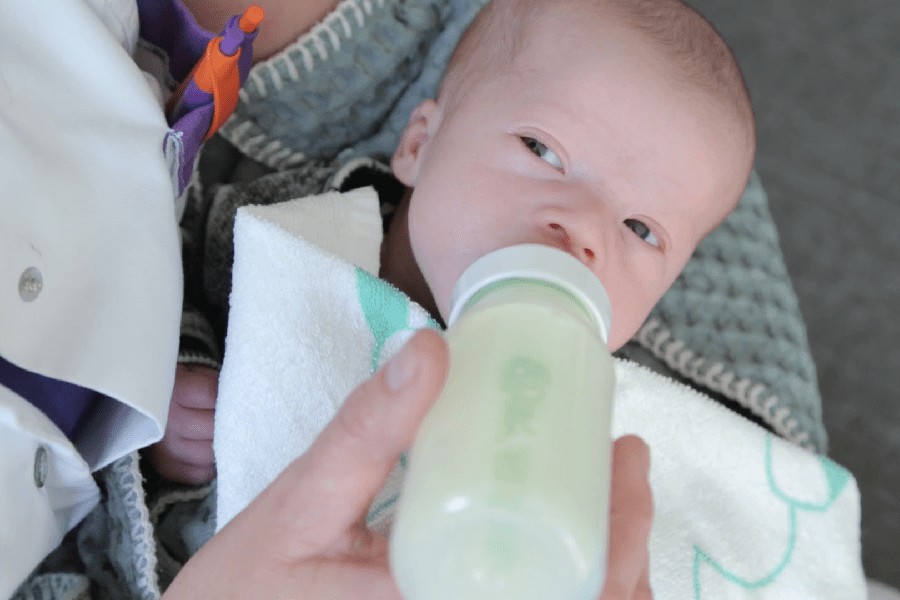 Kraamverzorgende geeft baby de fles