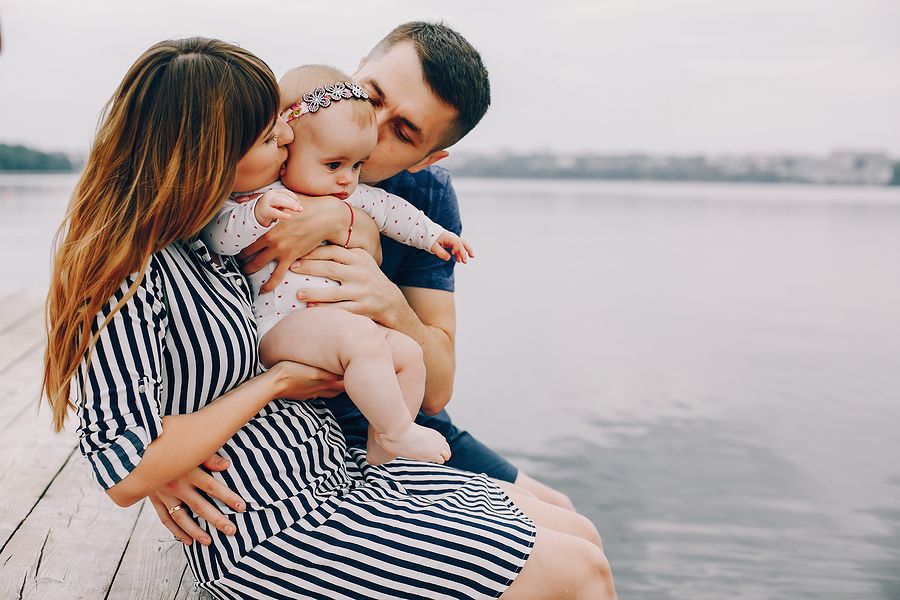 Ouders en baby genieten op een steiger van verlof rondom zwangerschap en ouderschap