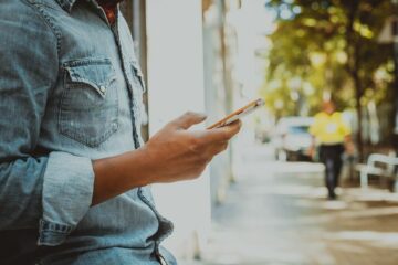 Aanstaande vader bekijkt checklist voor trimester 2 op telefoon