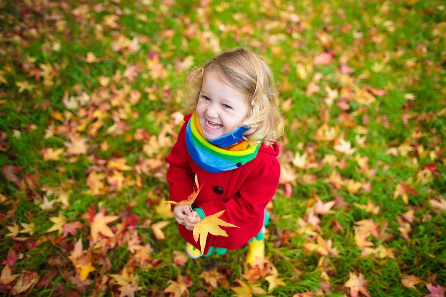 Meisje geniet van spelen in de natuur met herfstblaadjes