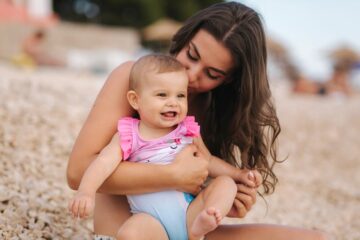 Moeder en baby op het strand moeten oppassen voor warmte uitslag