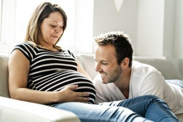 Moeder en vader kijken naar ingedaalde baby in de buik