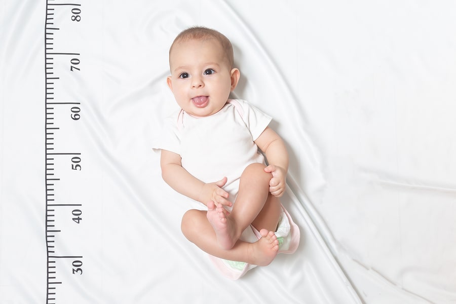 Baby ligt naast meetlint om de lengte te berekenen als je wil weten hoe lang wordt mijn kind