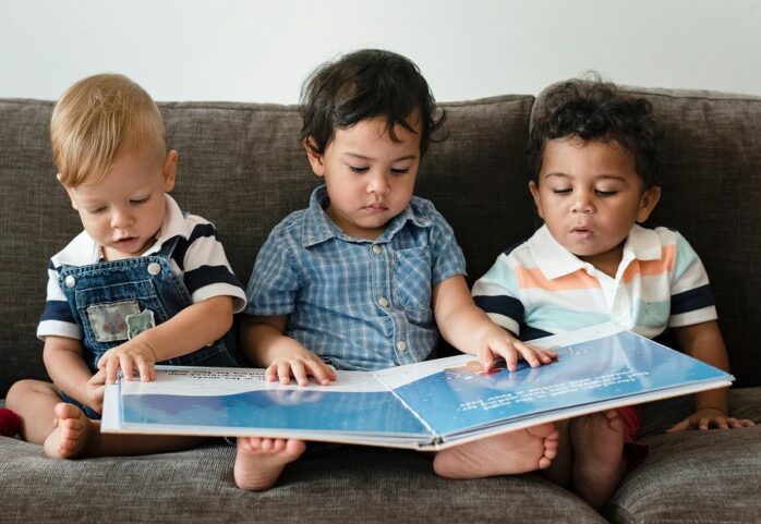 Drie jongetjes lezen samen een boek