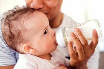 Baby krijgt flesje opvolgmelk van zijn vader