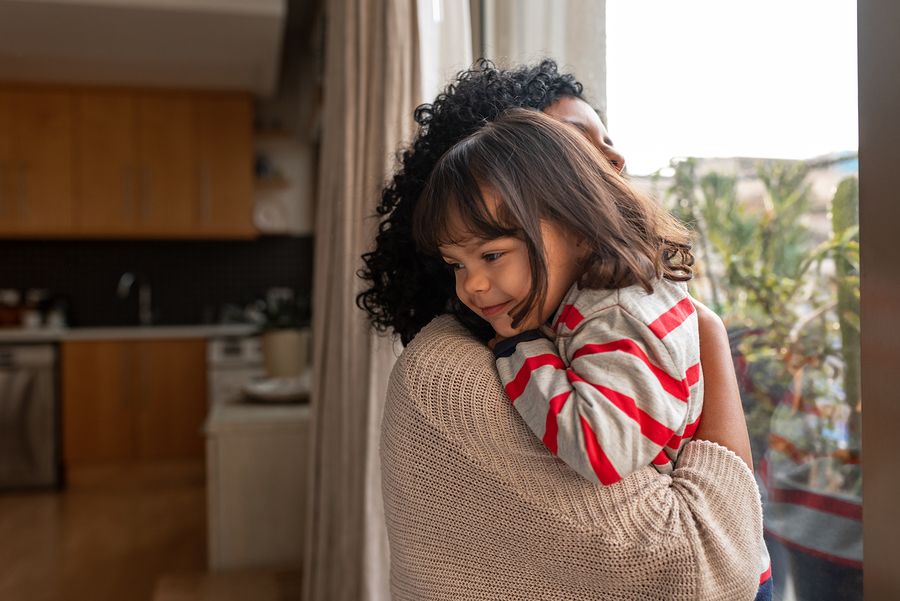 Moeder knuffelt kind met angst voor corona
