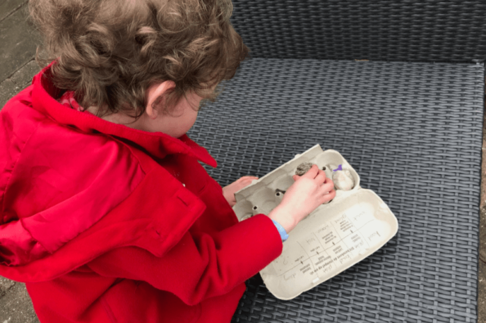 Meisje maakt een voeldoos in de tuin