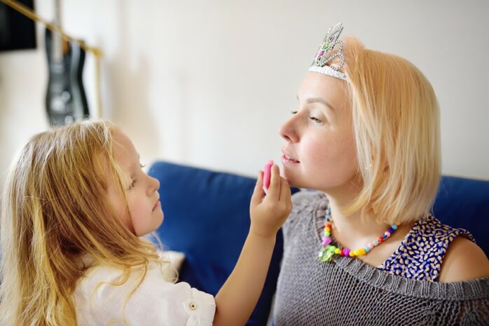 Meisje maakt haar moeder op als prinses als peuteractiviteit