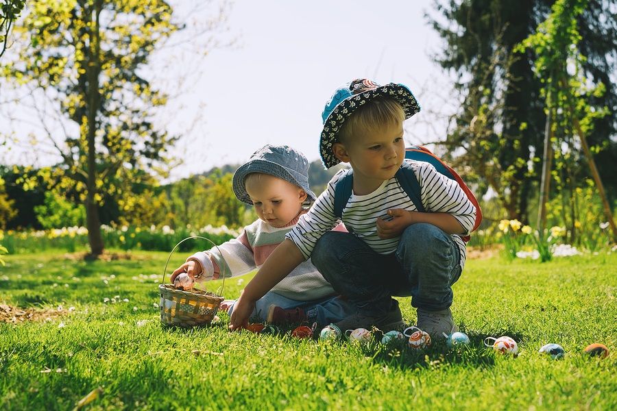 Peuter broer en zus vieren Pasen met eieren zoeken