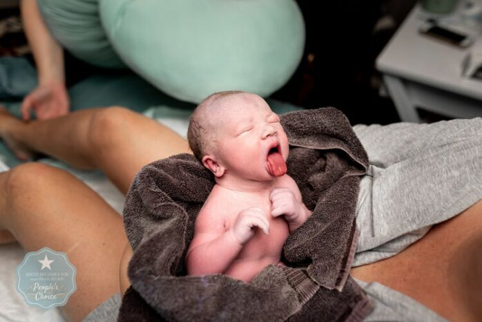 Pasgeboren baby steekt zijn tong uit