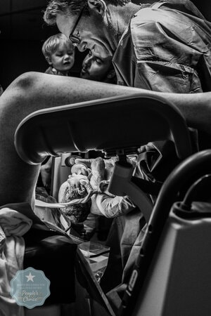 Vader en zoontje kijken mee met de bevalling