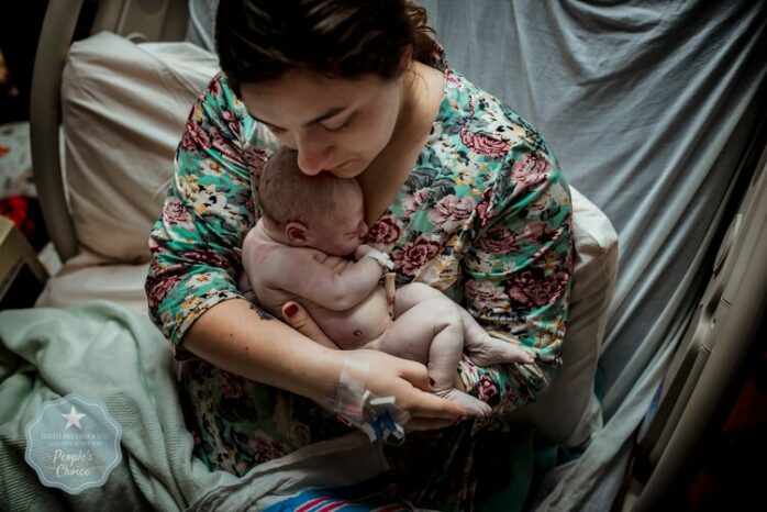 Kersverse moeder houdt haar pasgeboren baby vast