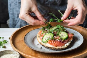 Vrouw slaat broodje zalm af tijdens zwangerschap