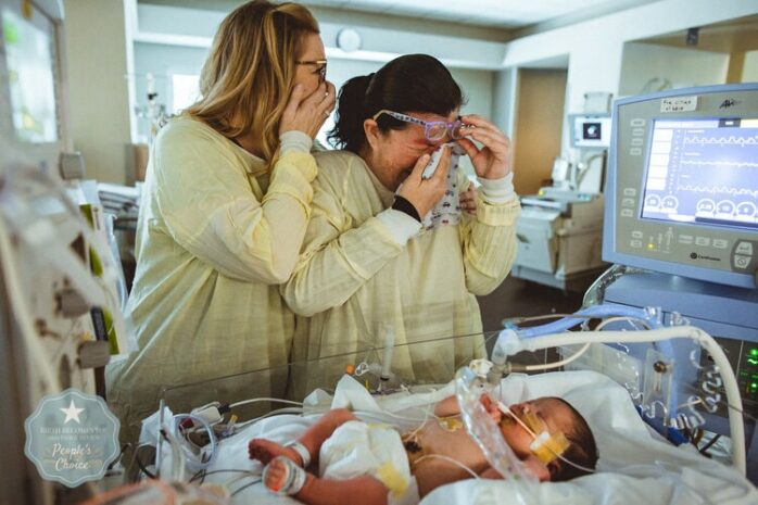 Tantes bekijken huilend de pasgeboren baby