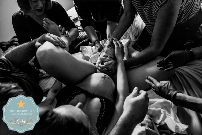 De partner pakt de baby aan die geboren wordt