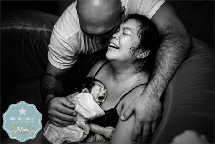 Geëmotioneerde vader en moeder houden hun pasgeboren baby vast