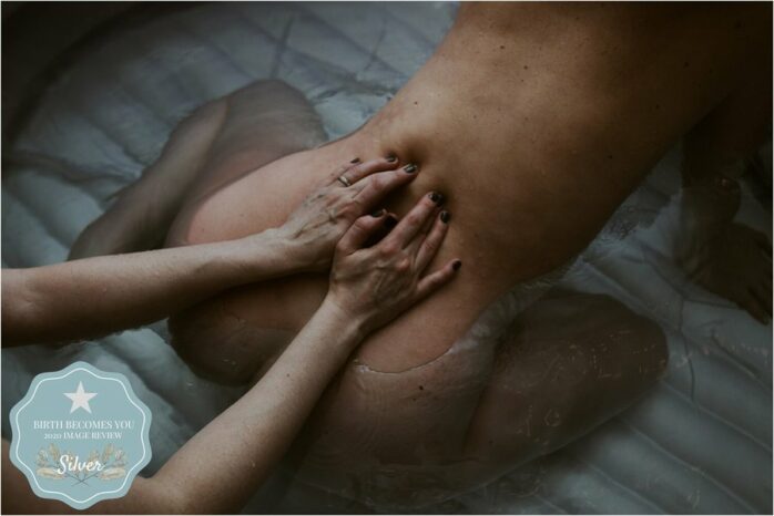 Partner drukt op de rug van zijn zwangere vrouw tijdens de bevalling