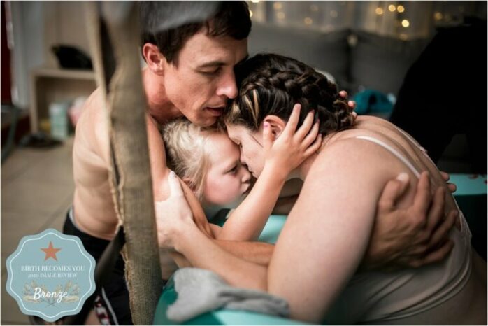 Man en kind houden hun moeder en vrouw vast