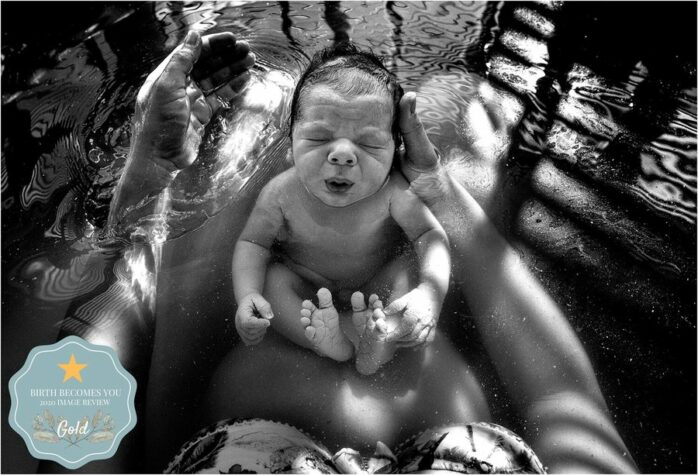 Moeder houdt haar pasgeboren baby vast in bad