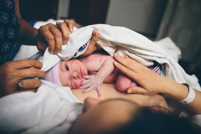 Pasgeboren baby knipoogt in de camera